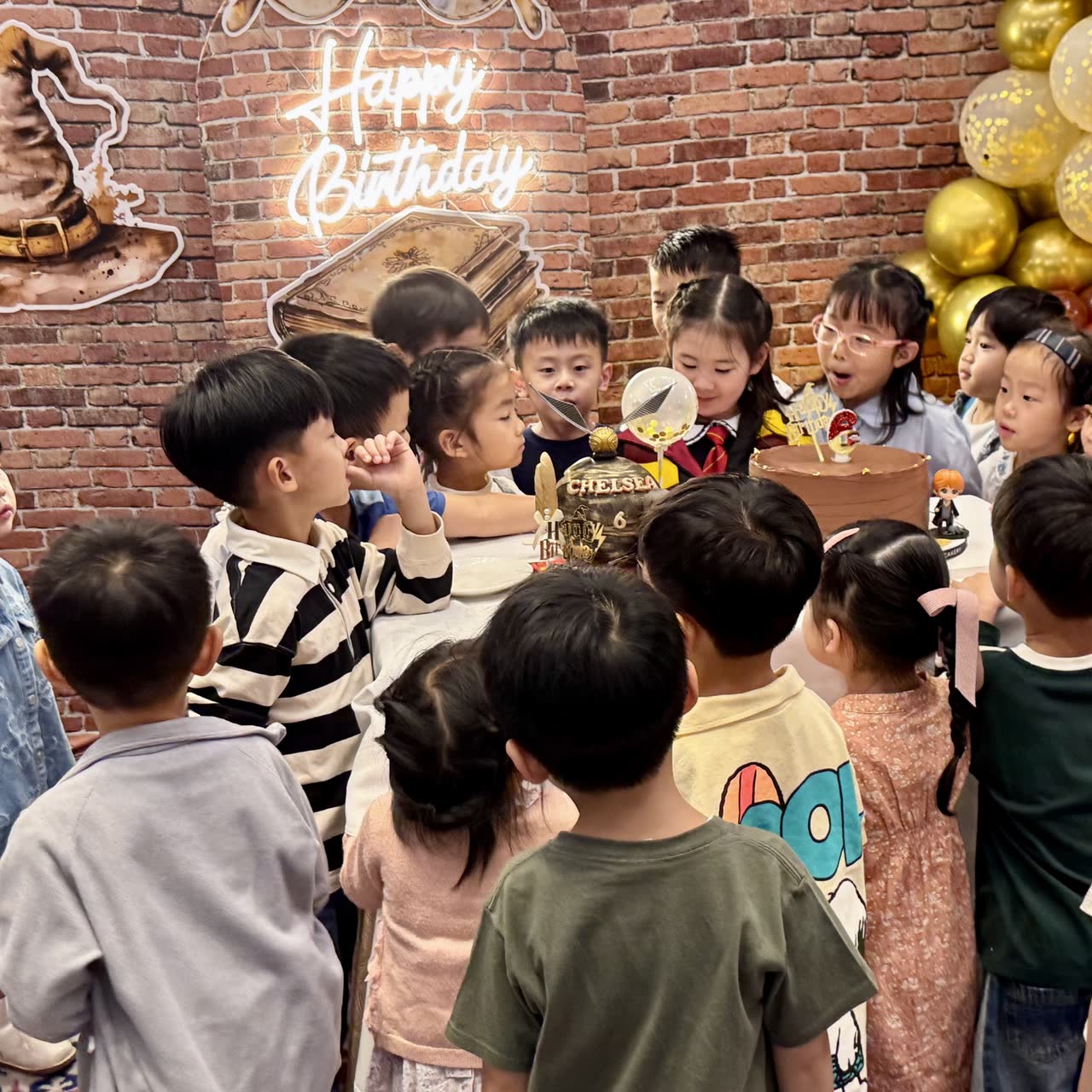 Children gathered around the birthday cake at a wizard-themed Newtonshow party in Hong Kong