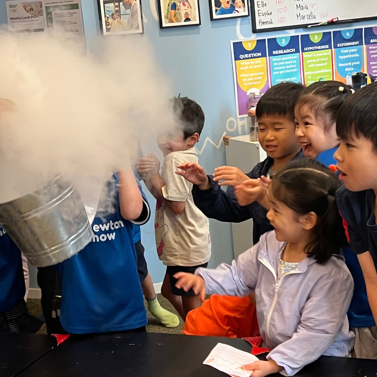 Children reaching into a huge cloud of dry-ice fog at a Newtonshow Hong Kong science camp